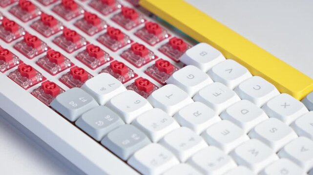 Zoomed-in shot of finger installing white keycap onto red switch during keyboard customization