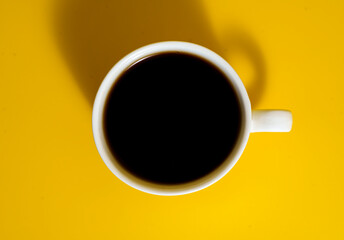 Top view of coffee cup on yellow background