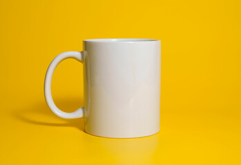 White ceramic mug on vibrant yellow background