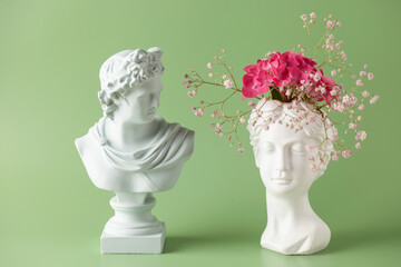 Creative art concept plaster head ancient sculpture with hair fresh flowers gypsophila and...