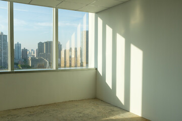 Obraz premium Light and shadow in the vacant room and the city skyline outside the window
