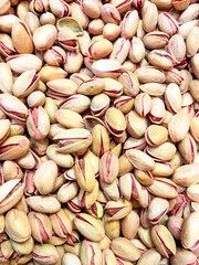 Abundance of raw pistachios with natural delicate pink hues in close up view