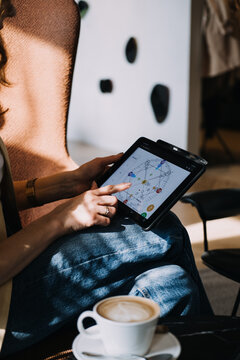 Numerologist using a tablet to interpret a digital numerology chart in a sunlit room. Modern numerology, metaphysical tech, intuitive design, spiritual analytics...