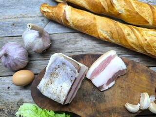 Freshly baked and sliced ​​French bread next to a delicious piece of lard on a cutting board