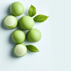 Delicious green matcha balls with leaves on a light background.