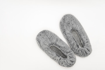 Fluffy gray home slippers isolated on white background. Bed shoes accessory footwear. Top view or flat lay.