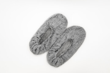 Fluffy gray home slippers isolated on white background. Bed shoes accessory footwear. Top view or flat lay.