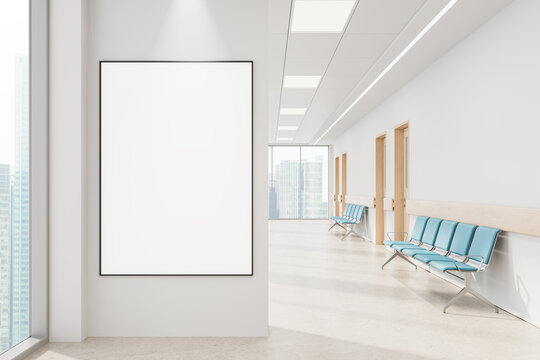 Blank vertical poster mockup on clean white wall in modern hospital corridor with blue chairs and wood doors, large windows with city view. 3D Rendering