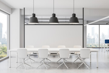 Modern white office meeting room with minimal furniture, large windows, and cityscape view in a...