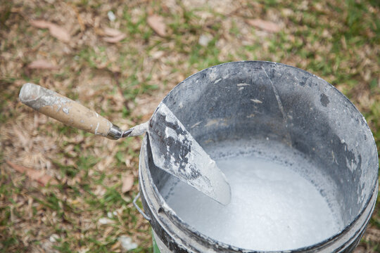 Tilers trowel on the edge of bucket or mortar