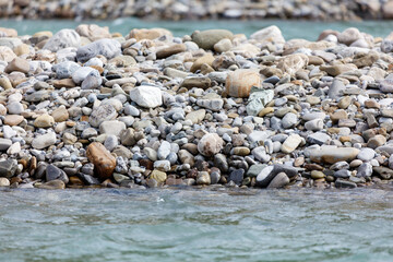 Obraz premium A rocky shoreline with a body of water in the foreground
