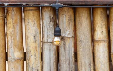 A light bulb is hanging from a wooden beam