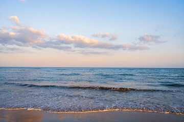 Fototapeta premium Tranquil ocean view as sunset colors paint the sky with soft hues.