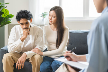 Psychology, depression asian young couple love woman and male patient consulting problem mental health with psychologist, psychiatrist at clinic together, wife encouraging husband, therapy health care