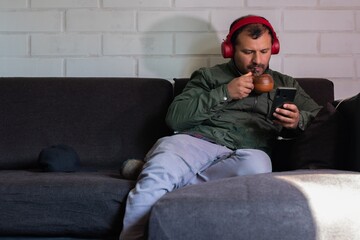 adult male with headset checks his cell phone