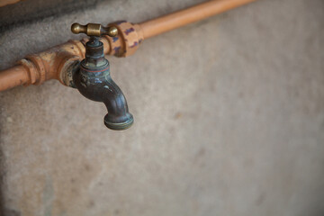 Pipe and tap outside building with copy space