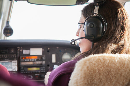 Young female adult flying a plane from the copilot seat
