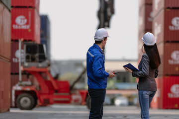 Foreman worker wear safety hardhat standing inspecting container cargo at warehouse storage terminal. Industrial engineer woman working at import export distribution port. Diverse people work together