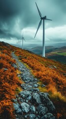A winding path amidst autumnal foliage and towering wind turbines under a dramatic sky.