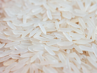 Close-up shot of dry, uncooked long grain basmati rice. Grains are slender and translucent, natural...
