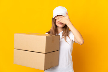 Young Slovak delivery woman isolated on yellow background covering eyes by hands. Do not want to...