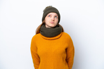 Teenager Russian girl wearing winter jacket isolated on white background and looking up