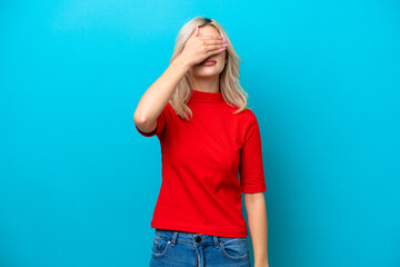 Young Russian woman isolated on blue background covering eyes by hands. Do not want to see something