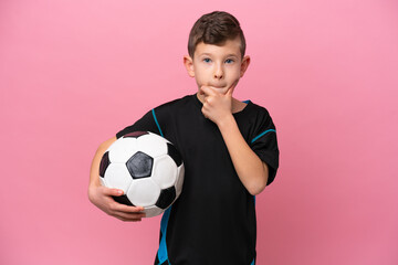 Little caucasian football player boy isolated on pink background having doubts and thinking