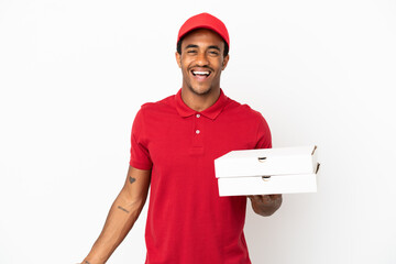 African American pizza delivery man picking up pizza boxes over isolated white wall smiling a lot