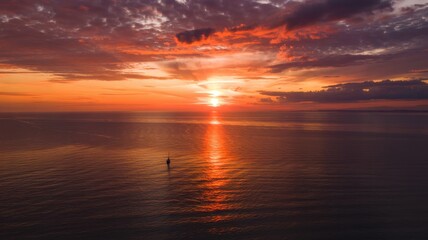 Obraz premium Fiery Red Sunset Sky Over Dark Waters With Floating Buoy