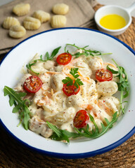 Italian gnocchi salad with cream and arugula. Top view table.