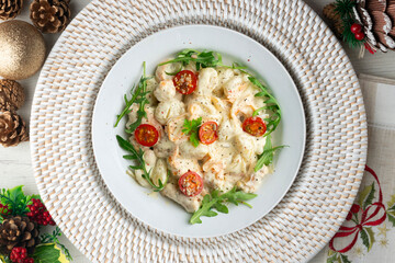 Italian gnocchi salad with cream and arugula. Top view table with christmas decoration.