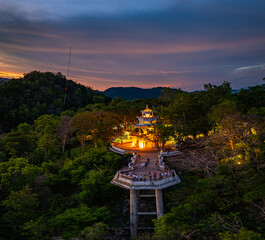 Aerial view of A radiant sunset fills the sky with golden and orange hues above Khao Rang viewpoint,  highlighting the natural contours of the hills and the quiet charm of the urban landscape below..