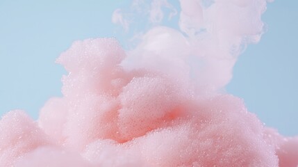 Fototapeta premium Light pink foam bubbles against a soft blue background, creating a dreamy and airy texture.
