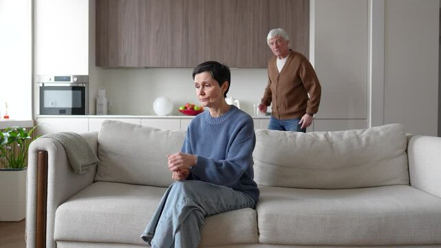 Terrified woman on sofa, enraged husband yells humiliates accuses of cheating faults. Relationship crisis, emotional abuse, verbal aggression, toxic marriage, psychological violence, oppressive spouse