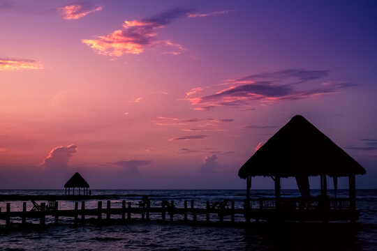 Purple sunrise over a  hut and wooden jetty, Akumal, Tulum, Mexico