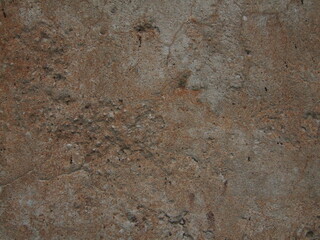 Detailed texture of weathered concrete surface showcasing natural imperfections and earthy tones in a close-up view
