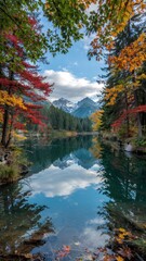 Obraz premium Crisp reflections of fall trees and snow mountains in calm teal alpine lake waters