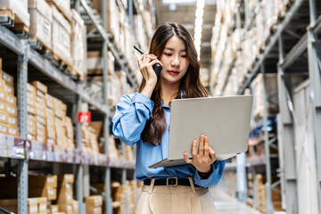 lively warehouse, dedicated young asian woman meticulously checks inventory details on her laptop...