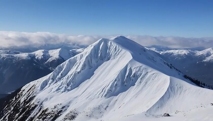 A snowy mountain peak under a clear blue sky with clouds in the distance on a sunny winter day