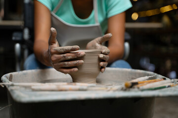 African woman make earth ware at workshop.