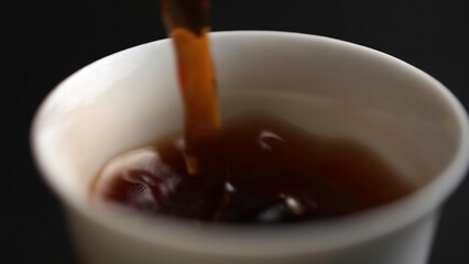 Carefully pouring a rich, dark beverage into a welcoming cup during a relaxing afternoon. Media