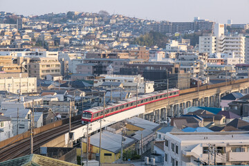 夕暮れの横浜上大岡の市街地をバックに走る電車