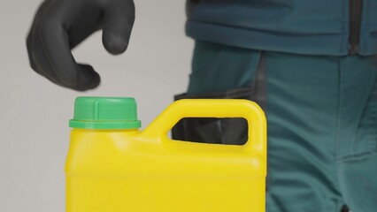 A man opens a yellow container with a green lid, revealing its contents. Creative