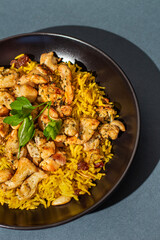 Chicken Fried Rice in black bowl with parsley, chicken breasts. Classic Chicken Fried Rice