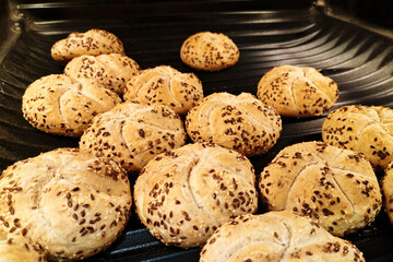 Fresh bread rolls baking. Homemade buns with seeds. Golden brown bread closeup. Fresh baked bread on tray. Crunchy healthy breakfast. Home bakery concept. Artisan food background.