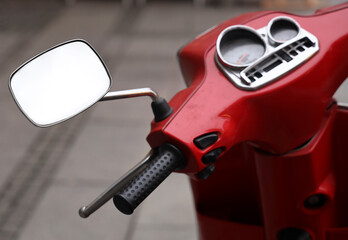 Naklejka premium white template mockup empty space in mirror. Steering wheel and dashboard of moped. Close-up. red vintage retro scooter on parking transport. part of moped with rear view mirror reflecting Mock-up