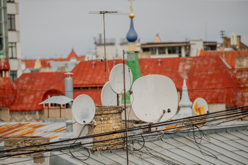 Big old city satellite dish antennas on rooftops in large city in old town for better tv channel...