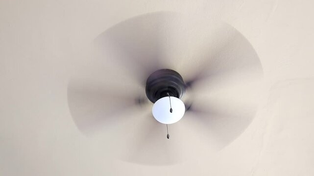 Ceiling fan fast spinning brown fin white lantern