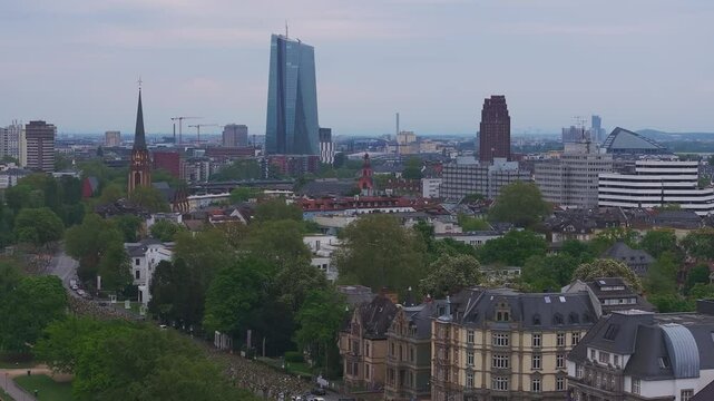 Aerial view of Frankfurt, Germany, showcasing the Main River, Eiserner Steg, historic and modern architecture, riverside greenery, and docked boats.